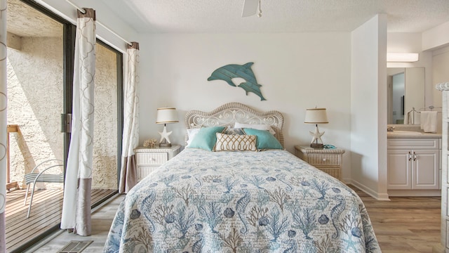 bedroom featuring a textured ceiling, connected bathroom, ceiling fan, and hardwood / wood-style floors