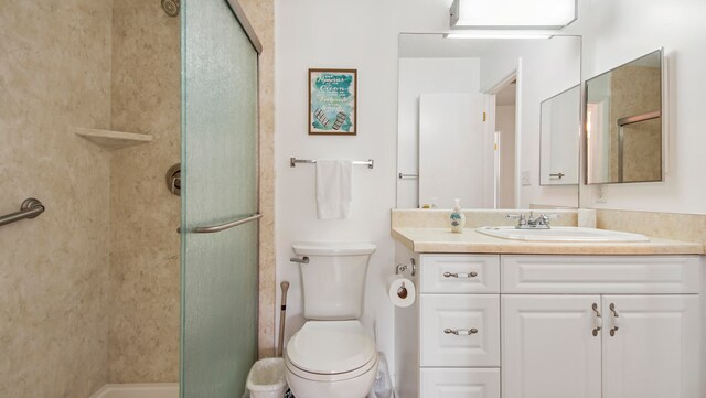 bathroom with walk in shower, vanity, and toilet