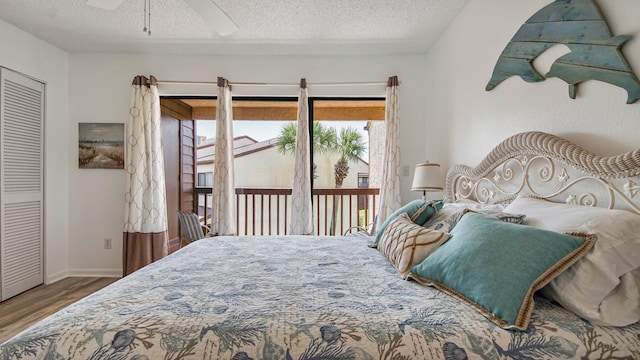 bedroom with ceiling fan, hardwood / wood-style flooring, access to outside, and a textured ceiling