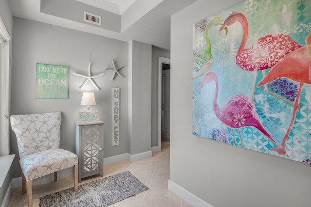 sitting room featuring light tile floors and a tray ceiling