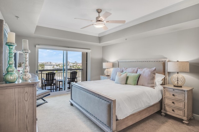 carpeted bedroom featuring ceiling fan, a tray ceiling, access to exterior, and crown molding