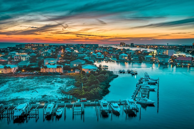 aerial view at dusk featuring a water view