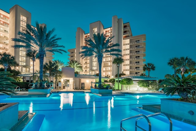 view of pool at twilight