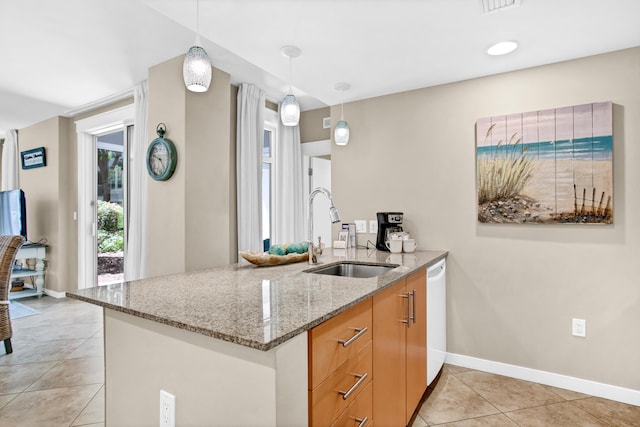 kitchen featuring pendant lighting, sink, light stone counters, light tile patterned flooring, and kitchen peninsula