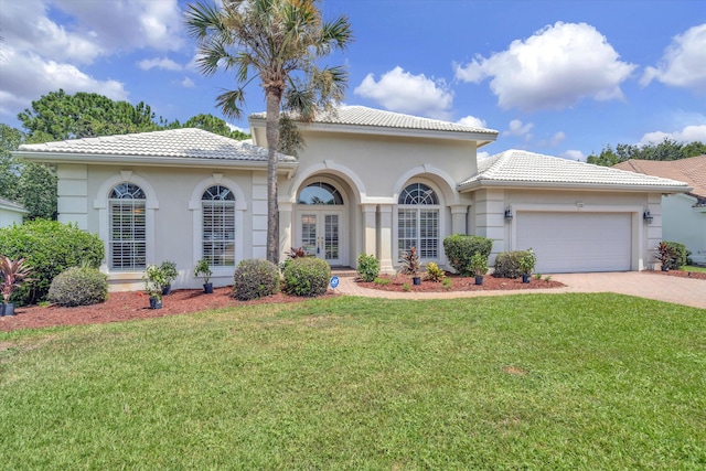 mediterranean / spanish-style home with a front yard and a garage