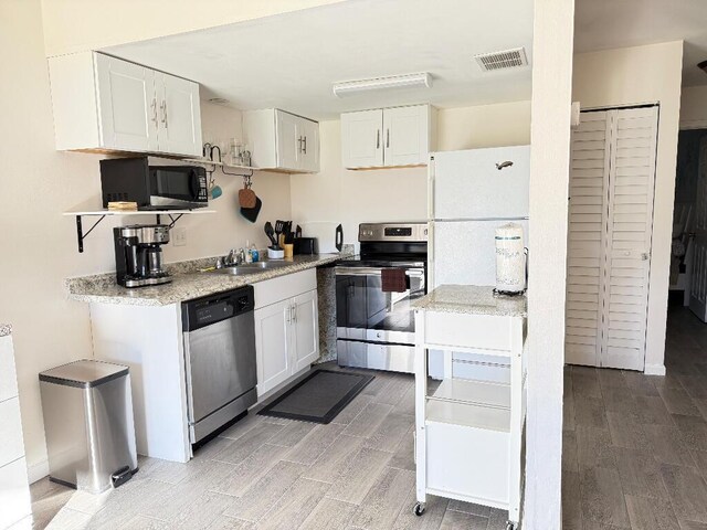 kitchen featuring appliances with stainless steel finishes, sink, and white cabinets