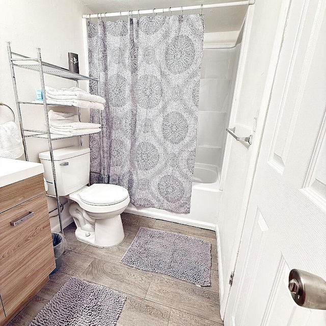 full bathroom featuring vanity, shower / tub combo with curtain, and toilet