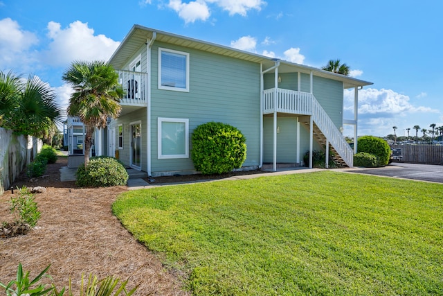 view of front of house featuring a front yard and a balcony