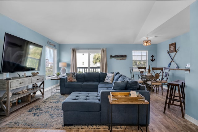 living room with dark hardwood / wood-style flooring, a healthy amount of sunlight, and vaulted ceiling