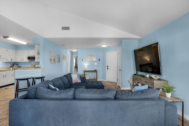 living room with vaulted ceiling and light tile floors