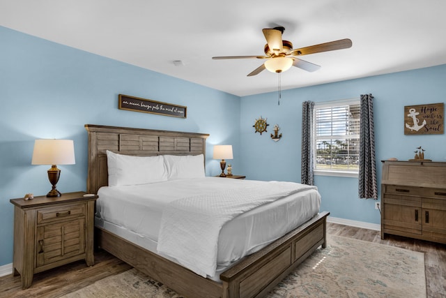 bedroom with dark hardwood / wood-style floors and ceiling fan