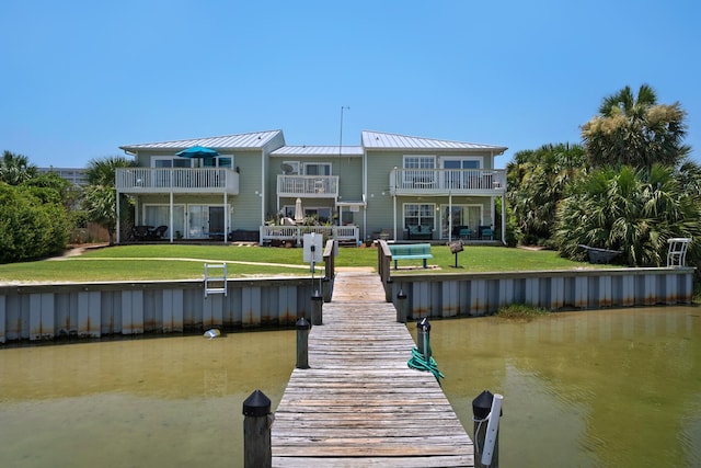 view of dock featuring a balcony, a yard, and a water view