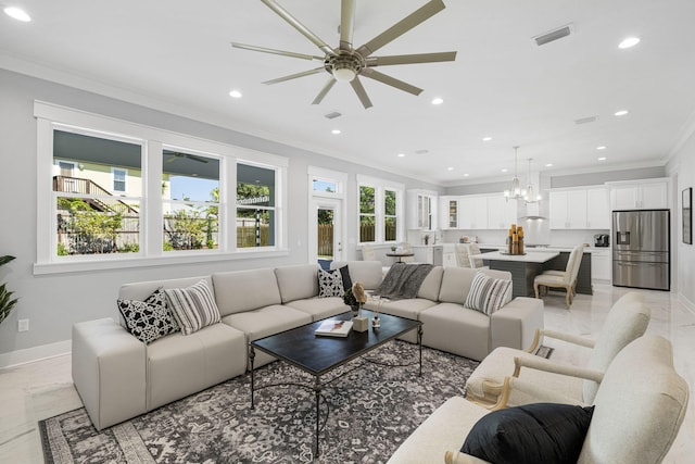 tiled living room with ornamental molding and ceiling fan with notable chandelier