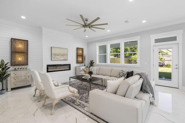 living room with ornamental molding, ceiling fan, light tile floors, and wood walls