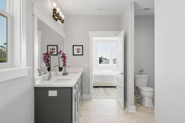 bathroom with toilet, tile flooring, and double vanity