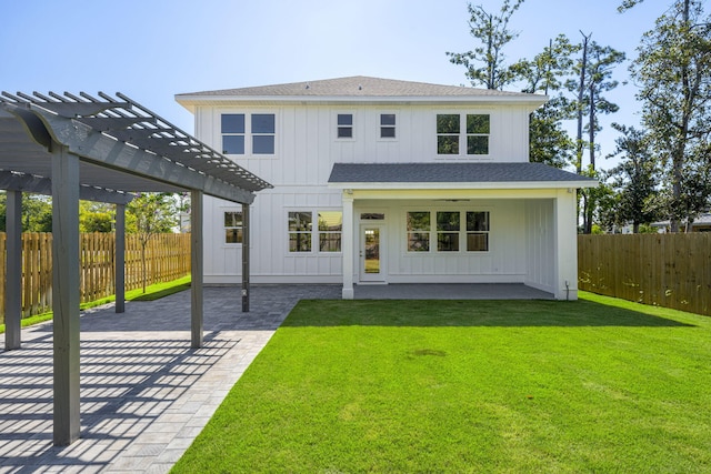 back of property with a patio area, a pergola, and a lawn