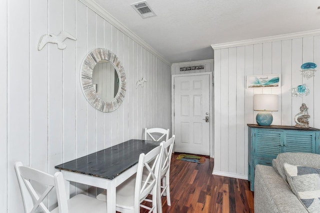 dining space featuring crown molding, dark hardwood / wood-style floors, and a textured ceiling