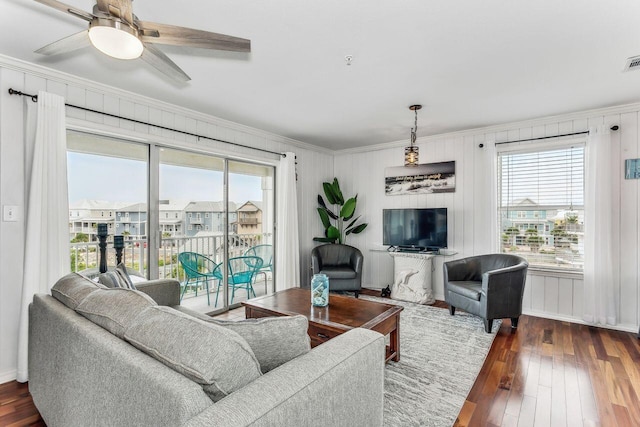 living room featuring crown molding, dark wood-type flooring, and ceiling fan