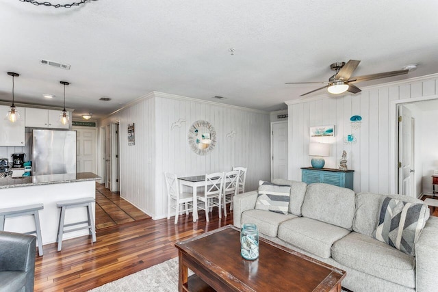 living room featuring ceiling fan and dark hardwood / wood-style flooring