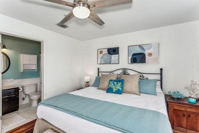 tiled bedroom with ceiling fan and ensuite bathroom