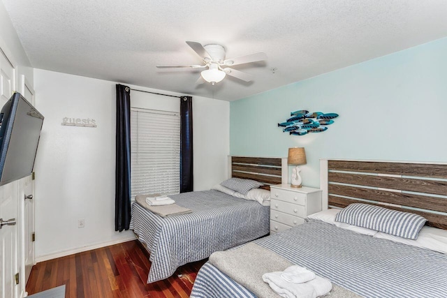 bedroom featuring ceiling fan, dark hardwood / wood-style floors, and a textured ceiling