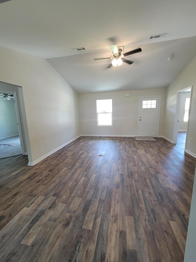 interior space featuring ceiling fan, dark wood-type flooring, vaulted ceiling, and a wealth of natural light