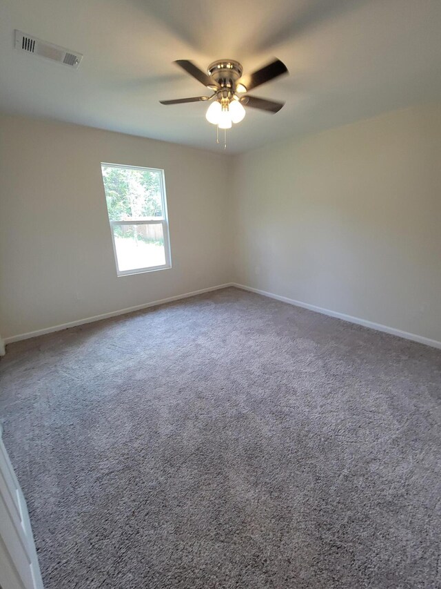 carpeted spare room featuring ceiling fan