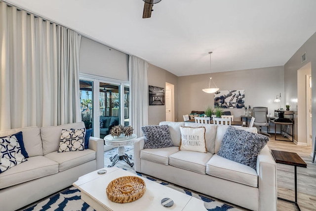 living room featuring light hardwood / wood-style flooring and ceiling fan