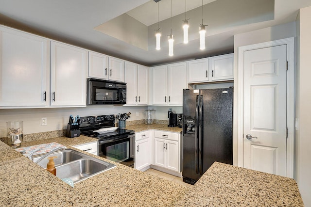 kitchen featuring hanging light fixtures, light tile flooring, white cabinetry, black appliances, and a tray ceiling