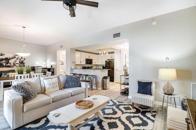 living room with ceiling fan and light hardwood / wood-style floors