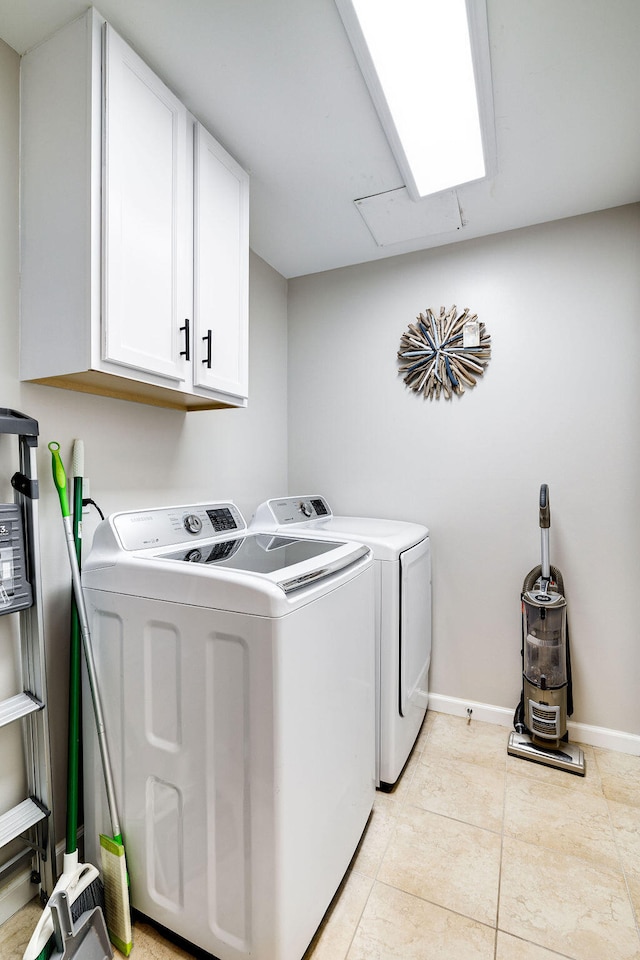 clothes washing area with a skylight, cabinets, washing machine and dryer, and light tile floors