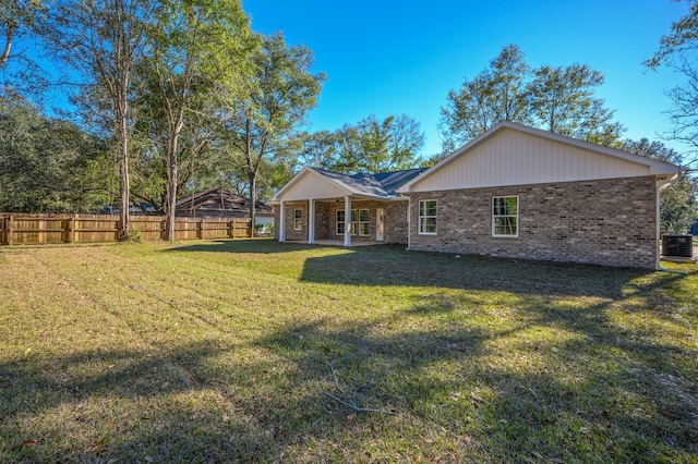 back of property featuring a yard and central AC unit