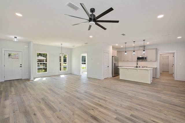 unfurnished living room featuring light hardwood / wood-style flooring and ceiling fan