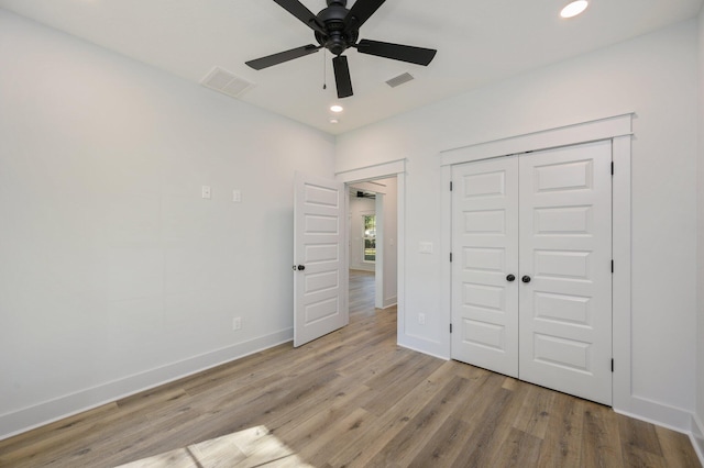 unfurnished bedroom featuring a closet, light hardwood / wood-style flooring, and ceiling fan