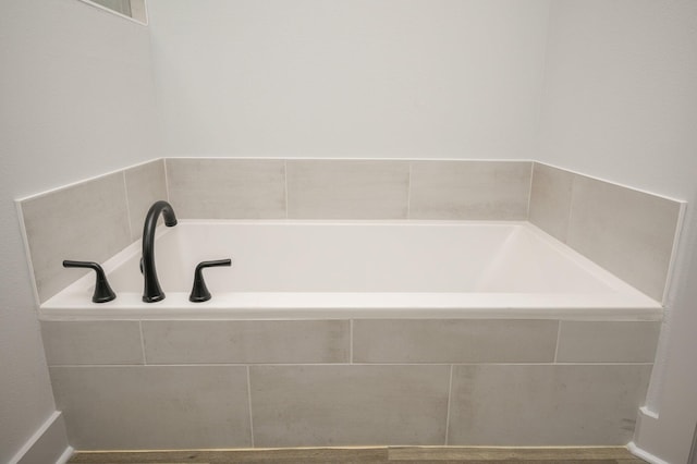 bathroom with a relaxing tiled bath