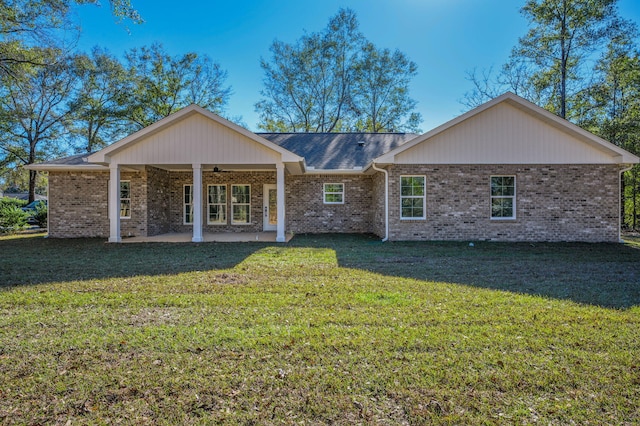 back of house featuring a lawn and a patio area