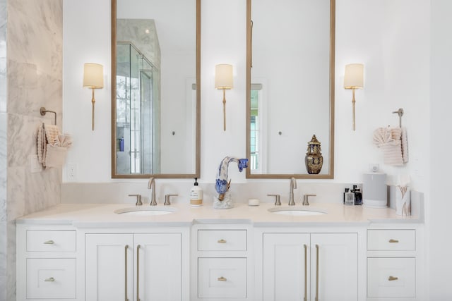 bathroom featuring dual bowl vanity and tiled shower