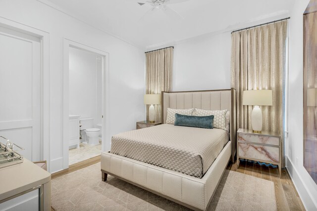 bedroom with ensuite bath, light hardwood / wood-style flooring, and ceiling fan