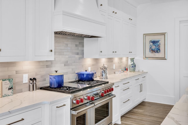 kitchen with premium range hood, double oven range, backsplash, and light wood-type flooring