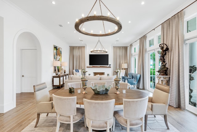 dining area featuring a chandelier, crown molding, and light hardwood / wood-style flooring