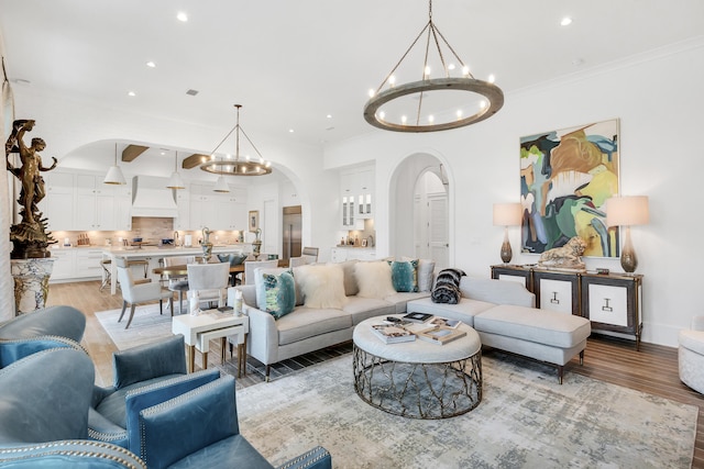 living room with ornamental molding, light hardwood / wood-style flooring, and a chandelier