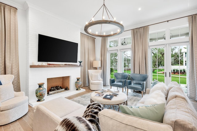 living room featuring light hardwood / wood-style flooring, french doors, an inviting chandelier, and ornamental molding