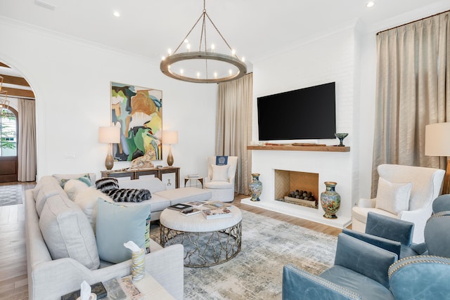 living room featuring a notable chandelier, crown molding, and light wood-type flooring