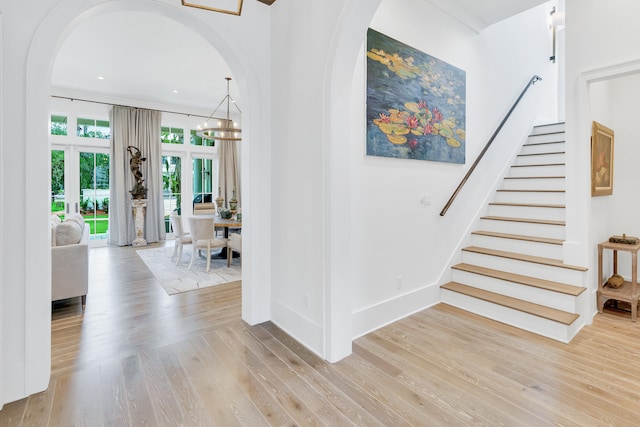 stairs with a chandelier and light wood-type flooring