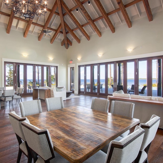 dining room with high vaulted ceiling, a water view, and dark wood-type flooring