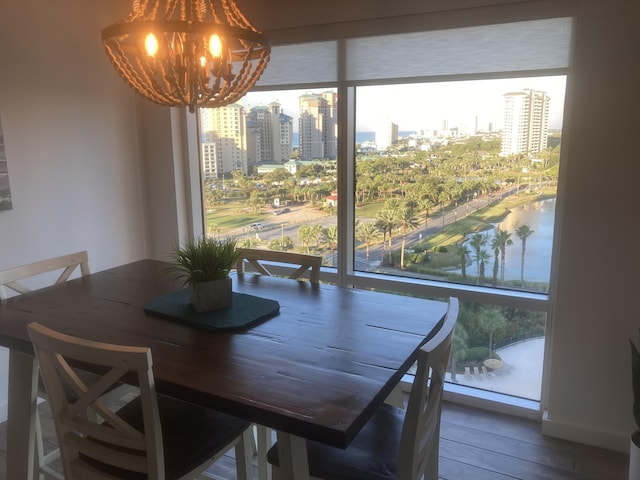 dining space with hardwood / wood-style flooring, plenty of natural light, and a chandelier