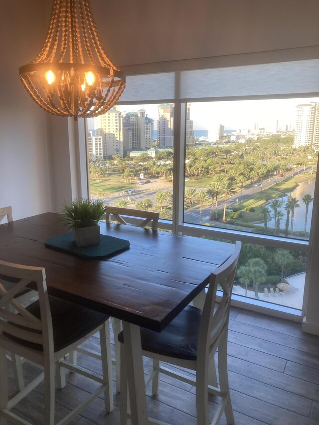 unfurnished dining area featuring wood-type flooring, a notable chandelier, and a wealth of natural light