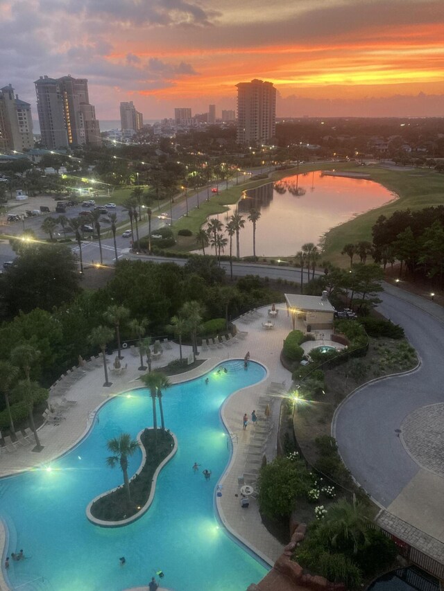 pool at dusk featuring a patio area