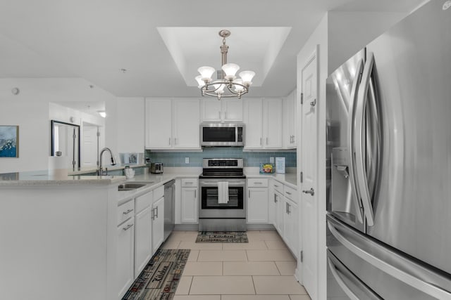 kitchen featuring light tile flooring, white cabinetry, a chandelier, appliances with stainless steel finishes, and tasteful backsplash