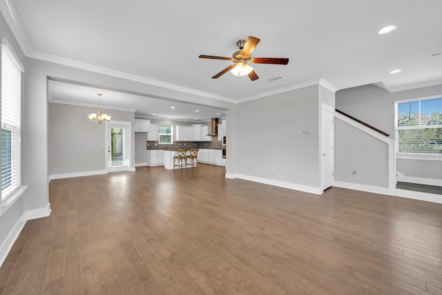 unfurnished living room featuring ceiling fan with notable chandelier, dark hardwood / wood-style flooring, and crown molding